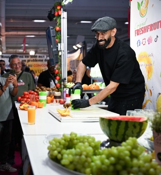Démonstration de presse-agrumes avec fruits frais et extraction de jus en direct sur un stand animé devant le public. Made in Paris