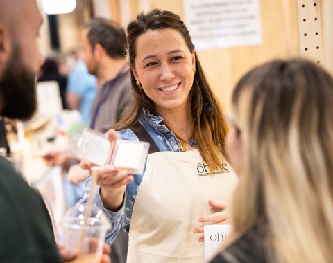 Créatrice présentant ses produits sur un stand Made in Paris