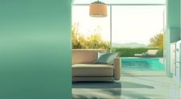 Salon moderne baigné de lumière naturelle avec canapé et vue sur piscine extérieure, illustrant un aménagement intérieur design ouvert sur l’extérieur. Foire de Paris