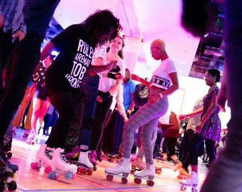 personnes faisant du roller en interieur ambiance festive soiree animation loisirs musique piste lumineuse