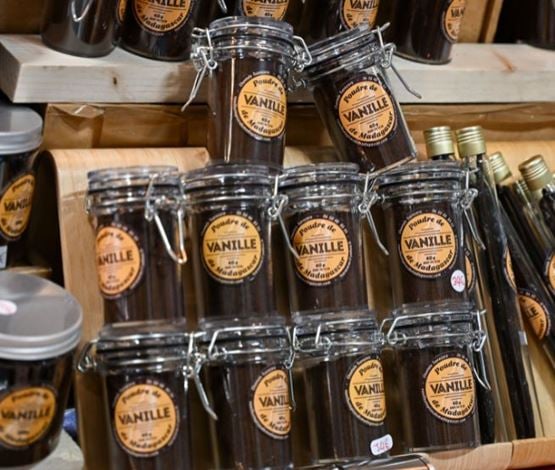 Pots de poudre de vanille de Madagascar empilés sur un stand de marché