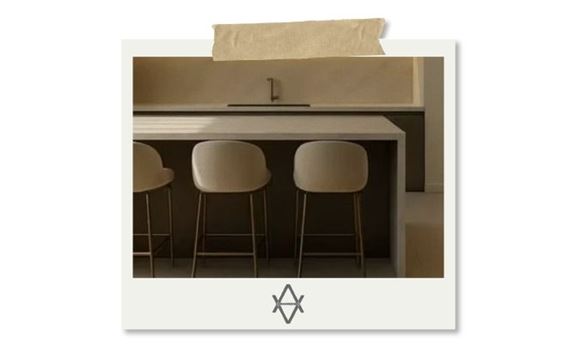 Cuisine minimaliste beige avec ilot central, trois tabourets hauts et eclairage LED sous meubles muraux.