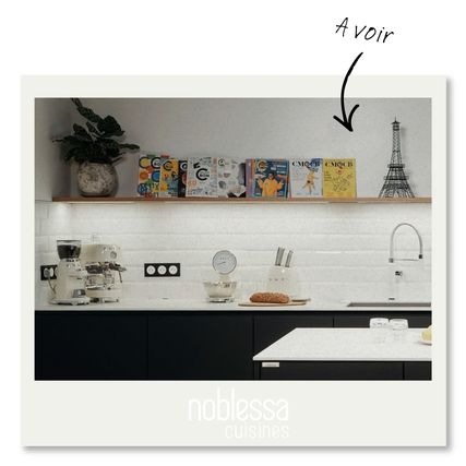 Cuisine moderne avec meubles noirs, credence en carrelage blanc, machine a cafe et magazines exposes sur une etagere.