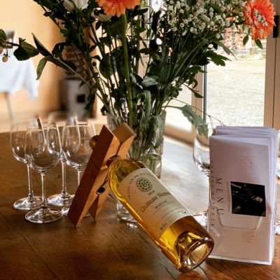 Sélection de vin blanc et verrerie disposée sur table en bois pour dégustation conviviale, made in paris.