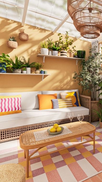 Une véranda colorée et ludique avec des coussins vifs, des plantes et un tapis à carreaux qui crée une atmosphère détendue et joyeuse.