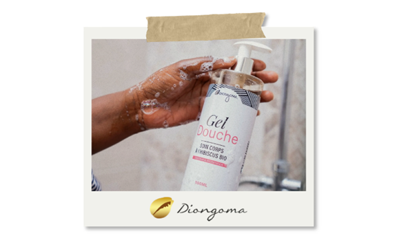 Flacon de gel douche à l'hibiscus bio de la marque Diongoma, présenté dans un geste de lavage.