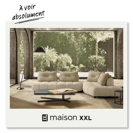 image montre un salon contemporain avec un grand canapé beige et confortable, entouré par une végétation luxuriante à l'extérieur. Ce design reflète une ambiance minimaliste mais accueillante, parfaite pour un espace de détente.