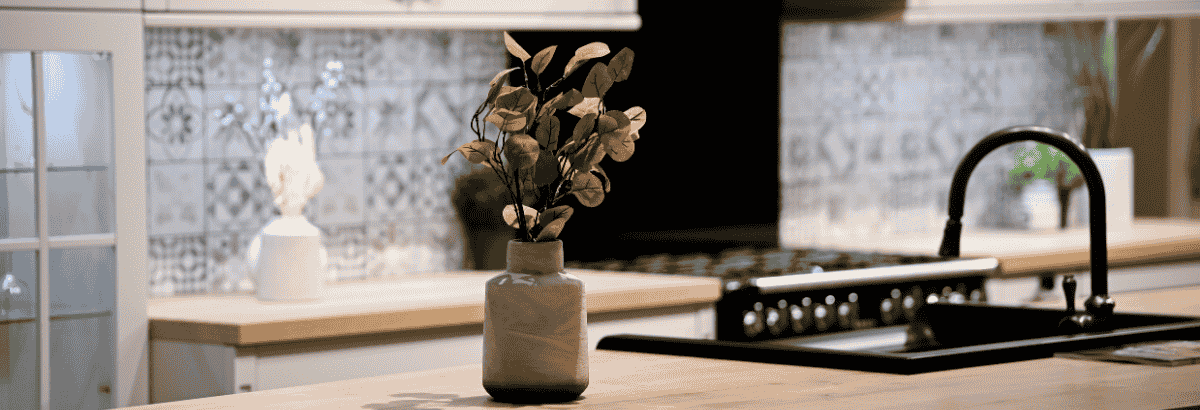 Cuisine moderne avec credence en carreaux motifs, evier noir et decoration minimaliste.