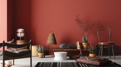 intérieur moderne et minimaliste avec une palette de couleurs chaudes et terreuses. Sur le mur, une peinture rouge brique sert de toile de fond à un espace cosy. - Home & Co paris - Foire de Paris