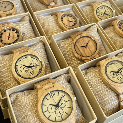 Montres en bois présentées dans des boîtes avec coussins en toile de jute.