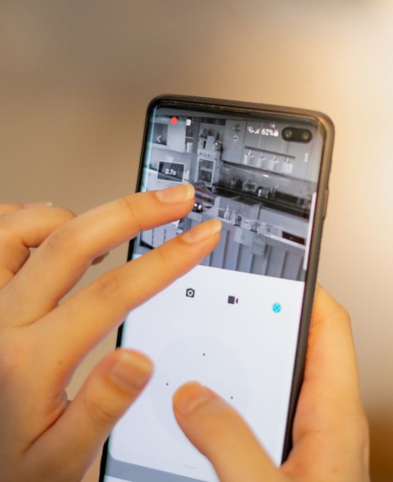 Personne contrôlant une caméra de surveillance via une application mobile sur smartphone.