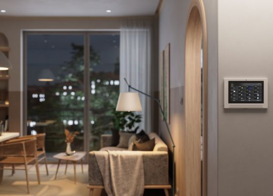 Salon moderne avec système domotique mural contrôlant les équipements connectés de la maison.