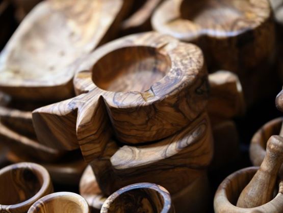 Objets artisanaux en bois sculpté, avec des bols et pièces décoratives aux veines naturelles.